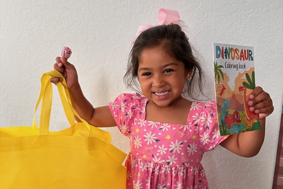 Student holding up book from home visit