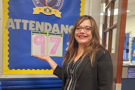 Collins Garden Principal with 97% attendance sign